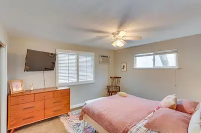 a bedroom with a bed and a flat screen tv at Mid-Century Mod Cottage, Steps to Lake Gregory! in Crestline