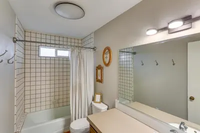 a bathroom with a sink toilet and a mirror at Mid-Century Mod Cottage, Steps to Lake Gregory! in Crestline