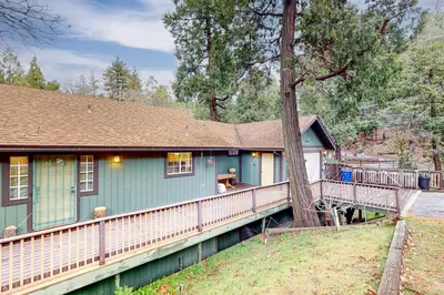 a blue house with a fence around it at Creekside Cabin in Crestline