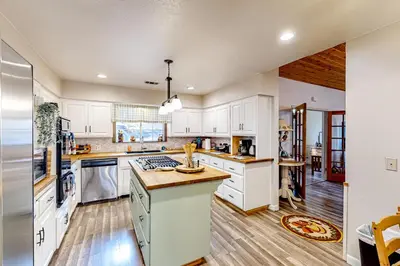 a kitchen with white cabinets and a counter top at Creekside Cabin in Crestline