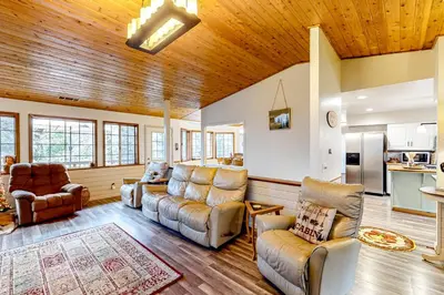 a living room with leather furniture and a wooden ceiling at Creekside Cabin in Crestline