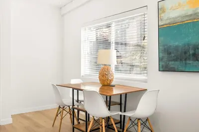 a dining room with a table and chairs and a window at NEW! Ocean View Mid-Century Modern Beach House in Manhattan Beach