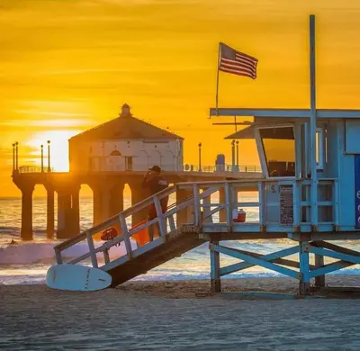 a person standing on a lifeguard station on a beach at NEW! Ocean View Mid-Century Modern Beach House in Manhattan Beach