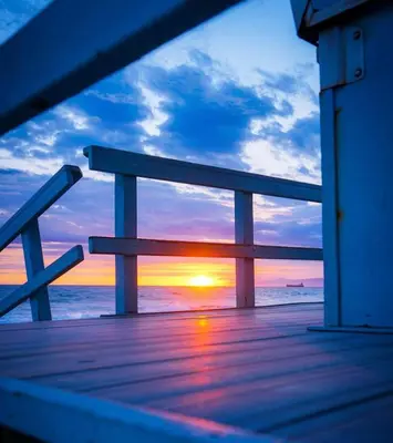 a view of a sunset from a wooden boardwalk at NEW! Ocean View Mid-Century Modern Beach House in Manhattan Beach