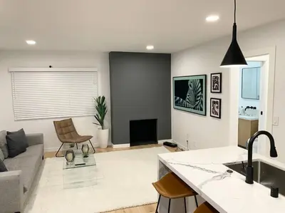 a kitchen and living room with a couch and a table at Brand New Ocean-View Beach Home Steps to the Sand! in Manhattan Beach