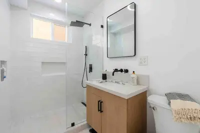 a bathroom with a shower and a sink and a mirror at Brand New Ocean-View Beach Home Steps to the Sand! in Manhattan Beach