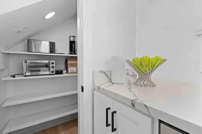 a kitchen with white cabinets and a counter top at Brand New Ocean-View Beach Home Steps to the Sand! in Manhattan Beach