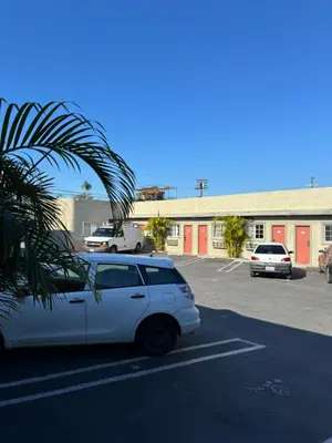 a white car parked in a parking lot at La Cienega Inn Motel in Los Angeles