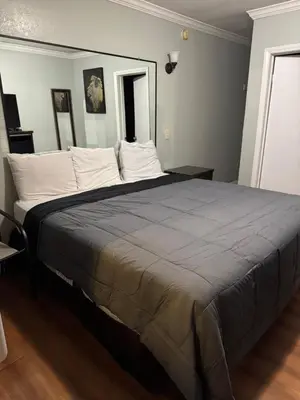 a bedroom with a large bed with white pillows at La Cienega Inn Motel in Los Angeles