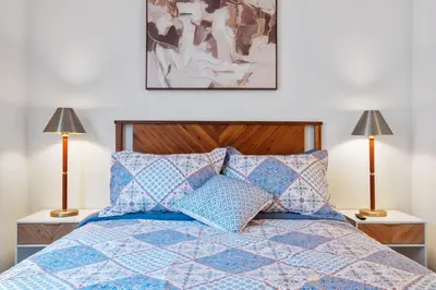 a bedroom with a blue bed with two lamps at 2 Santa Monica Beach Walking in Los Angeles