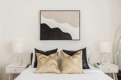 a bedroom with a bed with pillows and two lamps at Malibu Breeze - hot tub, ocean view, steps to beach in Malibu