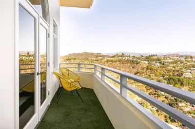 a balcony with a yellow chair and a view at Epic Views! Hollywood Hills SkyVilla: Crow's Nest in Los Angeles