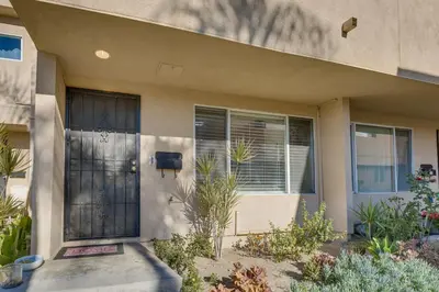 a house with a black door and some plants at Los Angeles Townhome Off-Street Parking and Balcony in Los Angeles