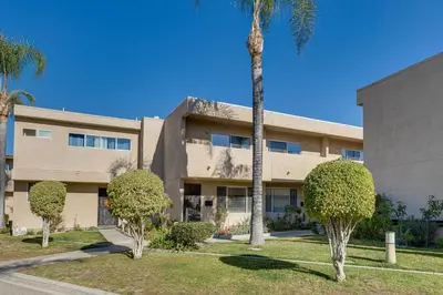 a building with a palm tree in front of it at Los Angeles Townhome Off-Street Parking and Balcony in Los Angeles