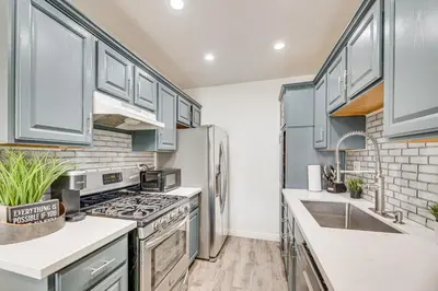 a kitchen with stainless steel appliances and blue cabinets at Los Angeles Townhome Off-Street Parking and Balcony in Los Angeles