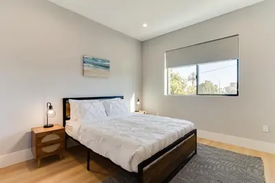 a bedroom with a large bed and a window at Brand New Modern 5 Bedroom House Pickfair Village in Los Angeles