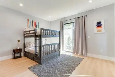 a childs bedroom with a crib and a large window at Brand New Modern 5 Bedroom House Pickfair Village in Los Angeles