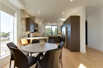 a kitchen and dining room with a table and chairs at Brand New Modern 4 Bedroom House Pickfair Village in Los Angeles