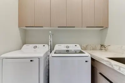 a kitchen with two white washers and a sink at Brand New Modern 4 Bedroom House Pickfair Village in Los Angeles