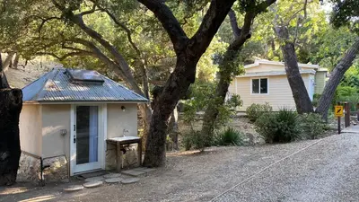 a small house with a bench next to a tree at Malibu Ranch Guest House Hideway in Malibu