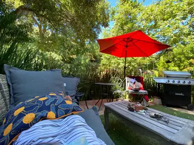 a red umbrella and a bed and a picnic table at Malibu Ranch Guest House Hideway in Malibu