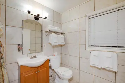 a bathroom with a toilet and a sink and a mirror at Arrowhead Tree Top Lodge in Lake Arrowhead