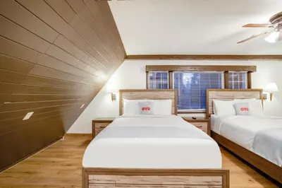 a bedroom with two beds and a window at Arrowhead Tree Top Lodge in Lake Arrowhead