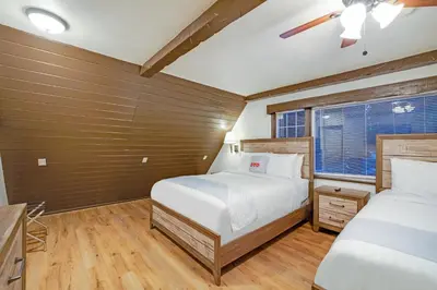 a bedroom with two beds and a window at Arrowhead Tree Top Lodge in Lake Arrowhead