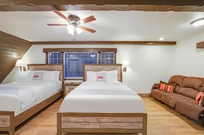 a bedroom with two beds and a couch at Arrowhead Tree Top Lodge in Lake Arrowhead