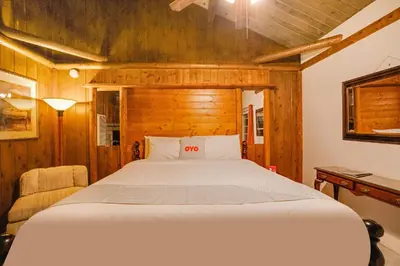 a bedroom with a large bed with a wooden wall at Arrowhead Tree Top Lodge in Lake Arrowhead