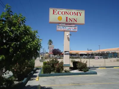 a sign for an economy inn in a parking lot at Economy Inn in Victorville