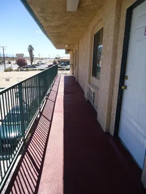 a hallway of a building with a white door at Economy Inn in Victorville