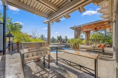 an outdoor patio with a grill and a table at ৎ୭The safty paradiseৎ୭ H/w Pool Jacuzzi &much more in Los Angeles