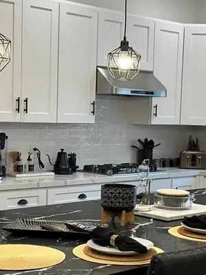 a kitchen with white cabinets and a stove top oven at The Verna Mae in Los Angeles