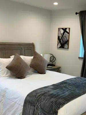 a bedroom with a bed with white sheets and pillows at The Verna Mae in Los Angeles