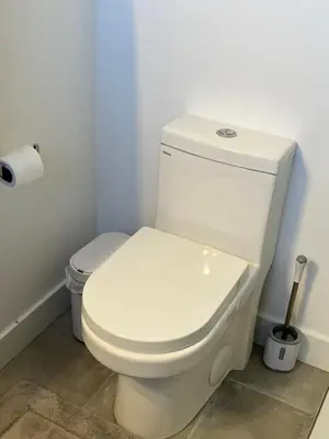 a white toilet in a bathroom with a roll of toilet paper at The Verna Mae in Los Angeles