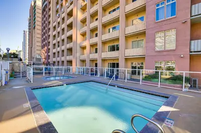 a swimming pool in front of a building at Luxe Long Beach Condo with Pool 1 Mi to Shoreline! in Long Beach