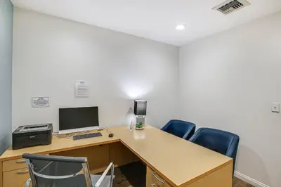 an office with a desk with a computer and blue chairs at Luxe Long Beach Condo with Pool 1 Mi to Shoreline! in Long Beach