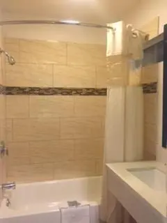 a bathroom with a tub and a toilet and a sink at Crenshaw Inn Motel in Los Angeles