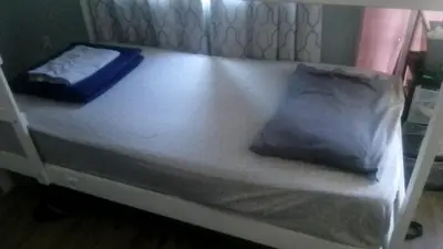 a white bed with two pillows on top of it at Robertson's Place Like Home in Los Angeles