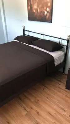 a bed in a bedroom with a wooden floor at Robertson's Place Like Home in Los Angeles