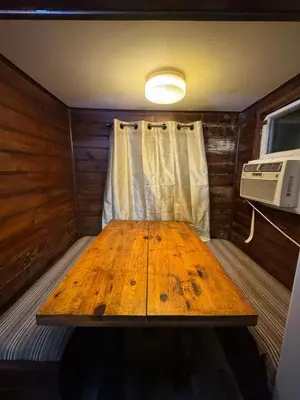 a wooden table in a small room with a microwave at Crest Lodge Historic Mountain Inn in Crestline