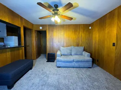 a living room with a couch and a ceiling fan at Crest Lodge Historic Mountain Inn in Crestline