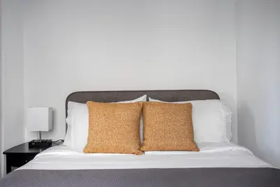 a bed with two pillows and a white wall at Blueground Fairfax pool nr mall dining LAX-1185 in Los Angeles