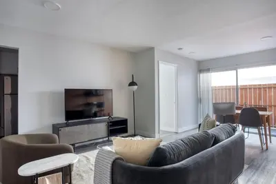a living room with a couch and a tv at Blueground Fairfax pool nr mall dining LAX-1185 in Los Angeles