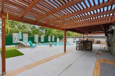 a patio with a wooden pergola and a swimming pool at Valley Glen Getaway in Van Nuys