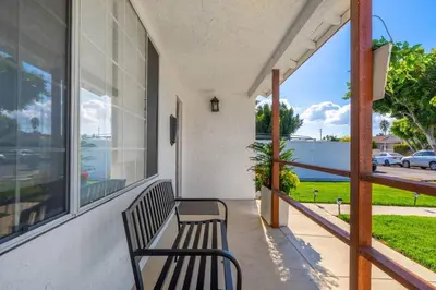 a bench sitting on the porch of a house at Acogedora Casa Cerca de Todo in Los Angeles