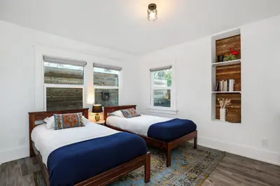 two beds in a room with two windows at Peace palace in Los Angeles