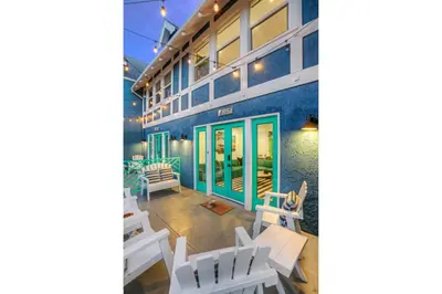 a patio with white chairs and a blue building at Peace palace in Los Angeles