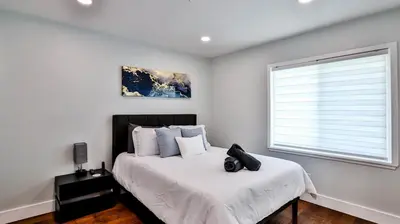 a bedroom with a large bed with a window at H&H Modern Lux 4BD 1 King Suite 3 Queen SoCal Disney in Westminster
